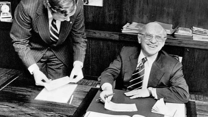 Nobel winning economist Milton Friedman receives his prize sum of $150,000 (U.S.) at PKbanken in Stockholm, from Claes G. Tisell, left, Dec. 13, 1976. Mr. Tisell is regional manager for Pkbanken in North America. (AP Photo/Reportagebild)