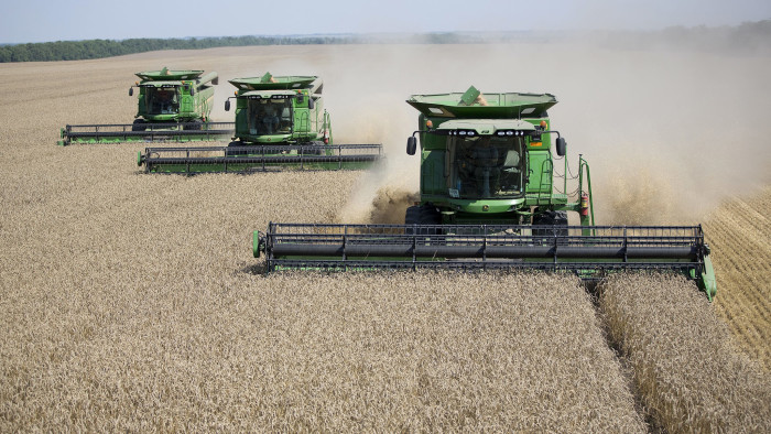 Wheat Harvesting In Russia...Farmers drive Deere & Co. combine harvesters across a field of wheat during harvesting near Kropotkin in Krasnodar region, Russia, on Friday, July 13, 2012. Russia's wheat crop is estimated at 45 million metric tons, with exports at 14 million to 17 million tons, Agriculture Minister Nikolai Fedorov said. Photographer: Andrey Rudakov/Bloomberg