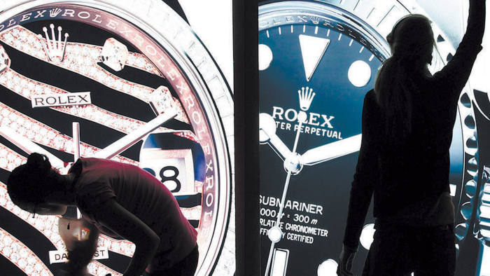 Workers polish illuminated display cases on the Rolex ahead of the Baselworld watch fair in Basel, Switzerland, on Wednesday, March 7, 2012