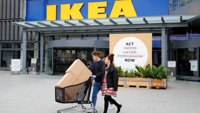 FILE PHOTO: Customers walk by a placard reading &quot;Act Now&quot; as they leave the IKEA store in Kaarst near Duesseldorf, Germany, April 3, 2019. REUTERS/Wolfgang Rattay/File Photo