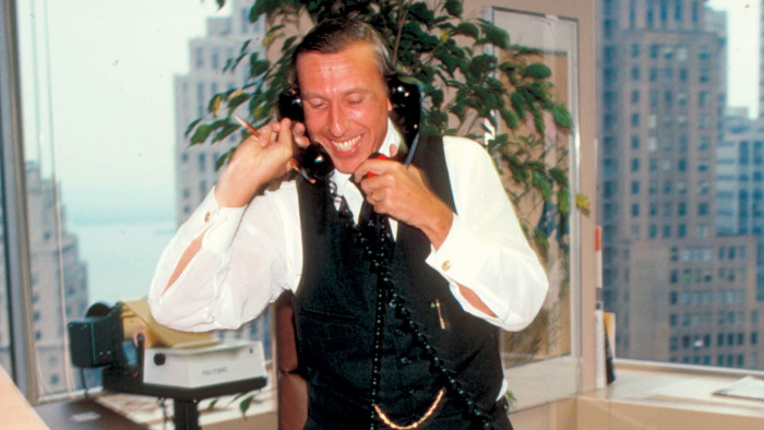 Risk arbitrageur Ivan Boesky working phones (one to each ear) in office