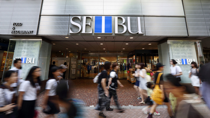 Pedestrians walk past a Seibu Department Stores Ltd. store in Tokyo, Japan, on Wednesday, July 30, 2014. Seibu Department Stores is part of the Seven & I Holdings Co. Group. Photographer: Tomohiro Ohsumi/Bloomberg