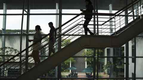 People walk down a set of stairs at the INSEAD Business School in Singapore, on Monday, Nov. 13, 2017. INSEAD had a perennial problem with its MBAs. The grades of female students consistently lagged those of men. So a professor did an experiment: She had all students, male and female, take a test to affirm their core values -- and managed to improve the grades of the women by 89 percent. Photographer: Wei Leng Tay/Bloomberg