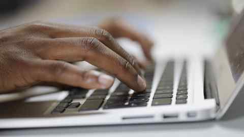 Closeup shot of Black woman typing on Laptop.
