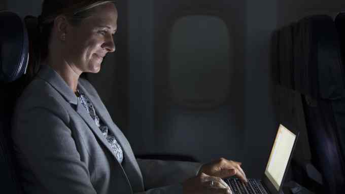 Business woman on airplane using a laptop