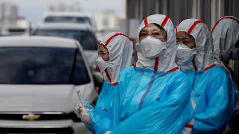 FILE PHOTO: Medical staff in protective gear work at a 'drive-thru' testing center for the novel coronavirus disease of COVID-19 in Yeungnam University Medical Center in Daegu, South Korea, March 3, 2020. To match Special Report HEALTH-CORONAVIRUS/RESPONSE REUTERS/Kim Kyung-Hoon/File Photo