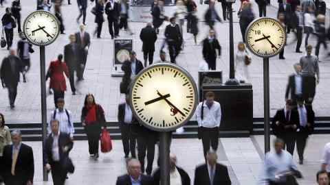 Workers walk past clocks at the Canary Wharf financial district in London, U.K. on Tuesday, Sept. 23, 2008. Stocks in Europe and Asia dropped,
led by financial companies and commodity producers, on concern
Treasury Secretary Henry Paulson's plan to buy $700 billion of
bank assets won't prevent a global recession. U.S. index futures
also declined. Photographer: Simon Dawson/Bloomberg News