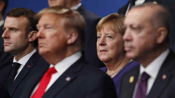 From left, French President Emmanuel Macron, U.S. President Donald Trump, German Chancellor Angela Merkel and Turkish President Recep Tayyip Erdogan pose during a group photo for a NATO leaders meeting at The Grove hotel and resort in Watford, Hertfordshire, England, Wednesday, Dec. 4, 2019. NATO Secretary-General Jens Stoltenberg rejected Wednesday French criticism that the military alliance is suffering from brain death, and insisted that the organization is adapting to modern challenges. (Peter Nicholls, Pool Photo via AP)