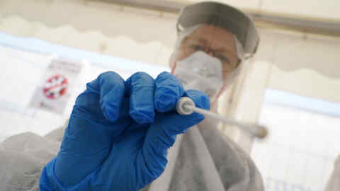 BERLIN, GERMANY - APRIL 23: An employee of the Berlin-Mitte district health office wearing PPE protective gear demonstrates taking a throat swab sample during a press opportunity at Berlin's first drive-in Covid-19 testing facility the day before its opening during the coronavirus crisis on April 23, 2020 in Berlin, Germany. Germany is seeking to expand its Covid-19 testing capacity in order to test not only health and emergency workers and people with Covid-19 symptoms, but also other parts of the population who might be asymptomatic.  (Photo by Sean Gallup/Getty Images)