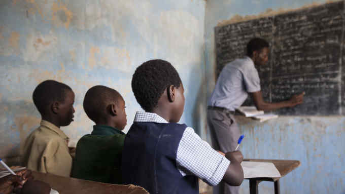 HARARE, ZIMBABWE - JANUARY 27: A teacher and students are seen during a lesson at a classroom of the makeshift schools to access affordable school lessons as they contend with a comatose national economy in Harare, Zimbabwe on January 27, 2020. Scores of pupils have no choice but to drop government or council schools in the southern African country as school fees have been shooting up now and then amid galloping inflation. As a way out, they turned to attending courses at makeshift schools to evade the astronomical fees. (Photo by Wilfred Kajese/Anadolu Agency via Getty Images)
