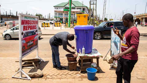 A man uses a public hand washing facility on a street of Accra after the lockdown announcement on March 28, 2020. - Ghana has announced a two-week lockdown in the country's two main regions starting Monday to curb the spread of coronavirus. The move came as the authorities reported 137 confirmed cases, including four deaths. (Photo by Nipah Dennis / AFP) (Photo by NIPAH DENNIS/AFP via Getty Images)