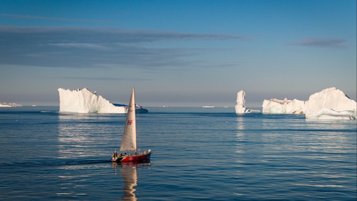 Boat sailing on the Arctic with icebergs in the background