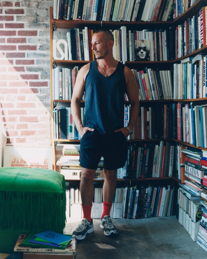 Jonathan Saunders at home in Brooklyn with part of his collection of books