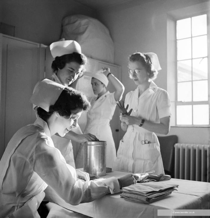 Four nurses prepare for work in a locker room