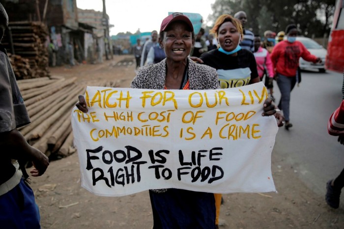 A protester holding up a sign, which says ‘Watch for our lives. The high cost of food commodities is a crime. Food is life. Right to food’