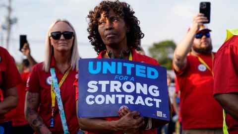 A woman holds a sign that reads ‘United for a strong contract’ during a rally to support striking workers outside a car assembly plant in Louisville, Kentucky
