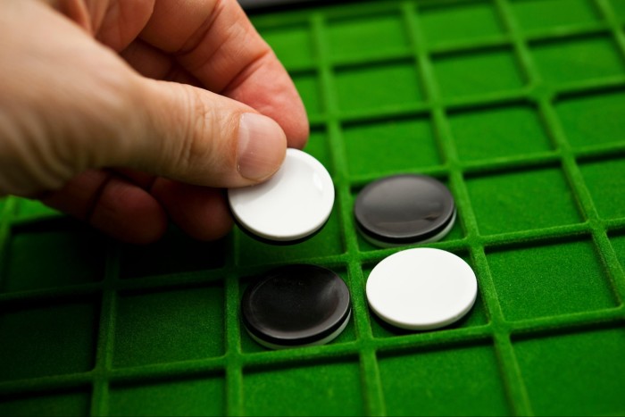 A player places a piece in the game of Othello