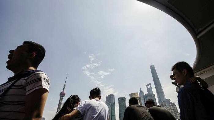 Tourists in Shangha ride on a ferry crossing the Huangpu River with Pudong’s Lujiazui financial district in the background