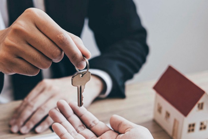 Estate agent giving house keys to client
