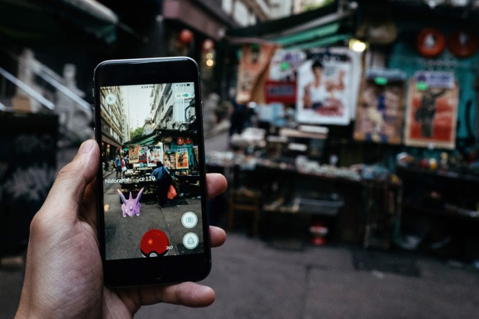 The Nidoran character of Nintendo Co.’s Pokemon Go augmented-reality game, developed by Niantic Inc., is seen in front of a stall on a smartphone