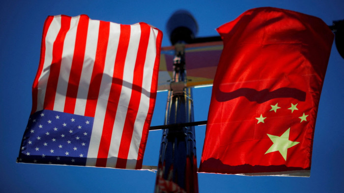 The flags of the United States and China fly from a lamppost