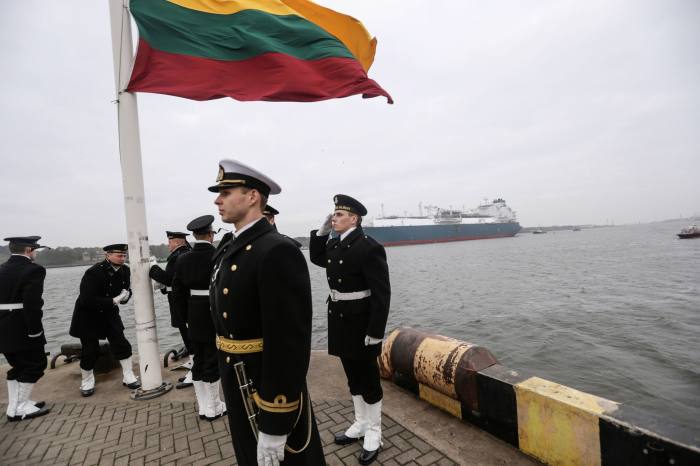 Navy personnel raise the Lithuanian flag as the Independence LNG facility moves into position in 2014