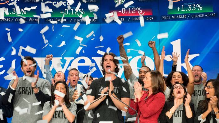 Adam Neumann co-founder and chief executive of WeWork surrounded by people at the Nasdaq in New York