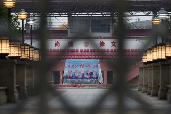 A banner displaying the Chinese core socialist values is seen through the entrance of a closed secondary school in Wuhan