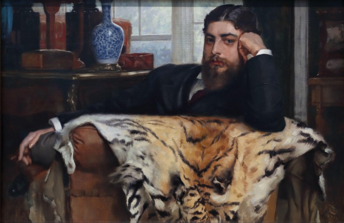 Oil painting of a man in a suit reclining on a chasie covered by a tiger skin