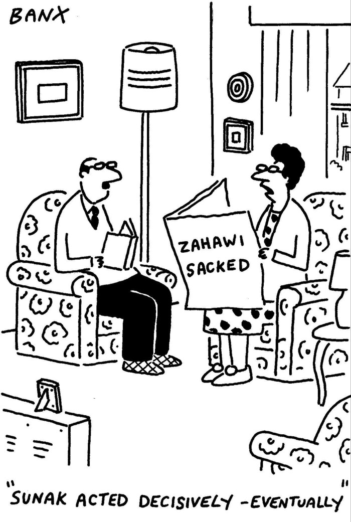 Cartoon of a man and woman talking to each other, seated on armchairs. The man is holding a book while the woman is holding a paper with the headline ‘Zahawi sacked’