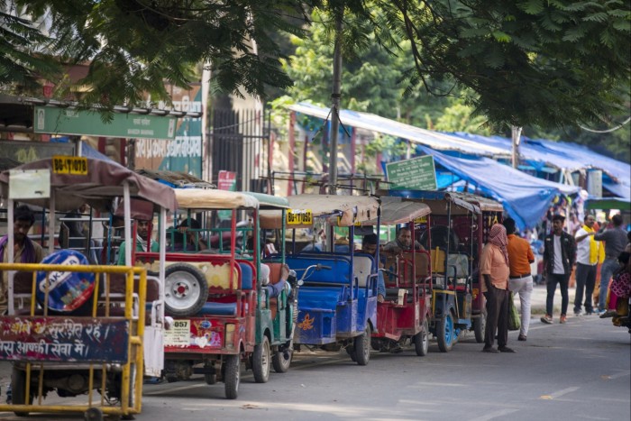 A line of parked rickshaw drivers wait for customers