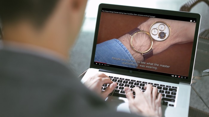 image of a watch on a laptop, with the laptop user in the foreground