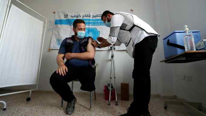 A Syrian medical worker receives a dose of the AstraZeneca’s Covid vaccine May 2021