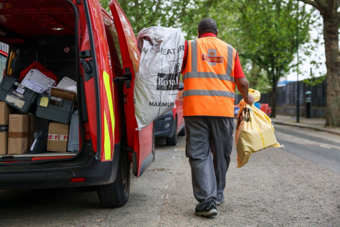 A postman loads his vehicle outside a collection office in London,