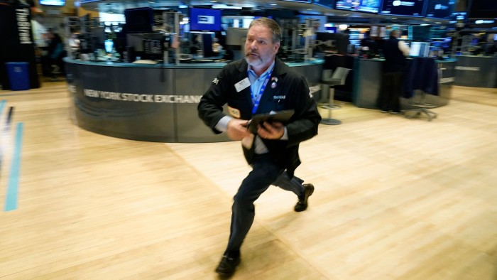 A man runs across the trading floor at the New York Stock Exchange