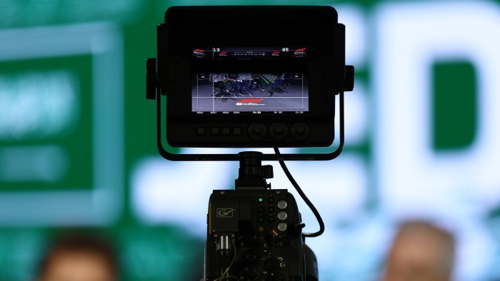 A TV monitor displays a Formula 1 race