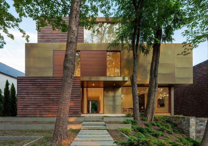 A striking modern detached building clad in alternating slabs of bronze panels and red clay brick tiles
