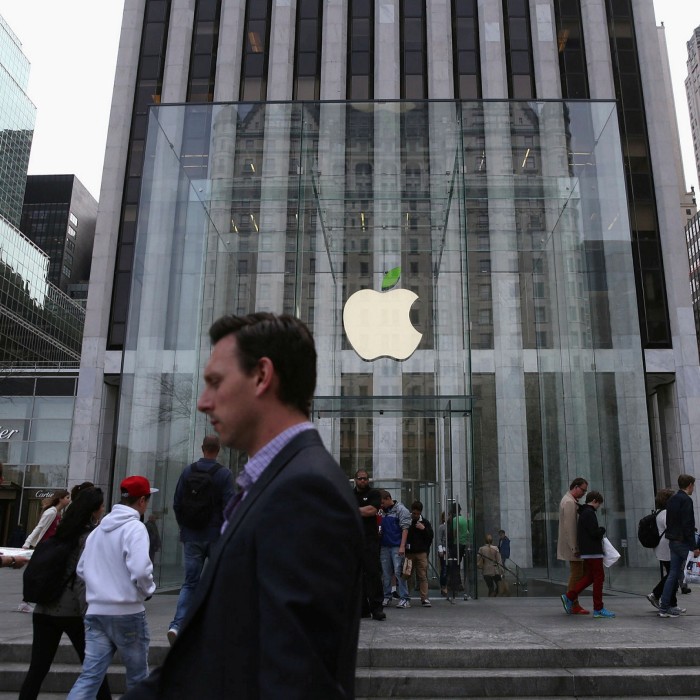 People walk past an Apple store in New York. The group plans to cut its missions by 75% by 2030 across its entire supply chain