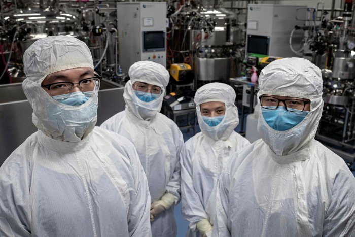 Sinovac engineers in a biotech lab in Beijing. The company has said it could complete phase two trials of a vaccine and go to production by July, according to local media