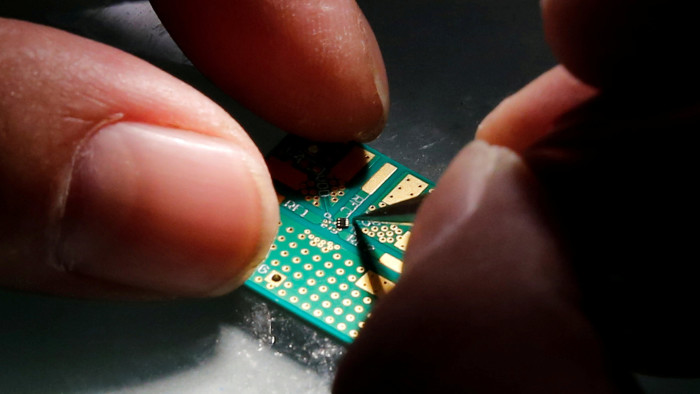 A researcher plants a semiconductor on an interface board 
