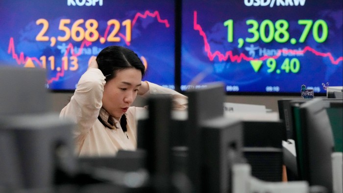 A currency trader watches monitors in Seoul, South Korea