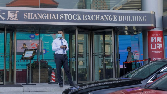 A man stands in front of the Shanghai Stock Exchange Building in Shanghai