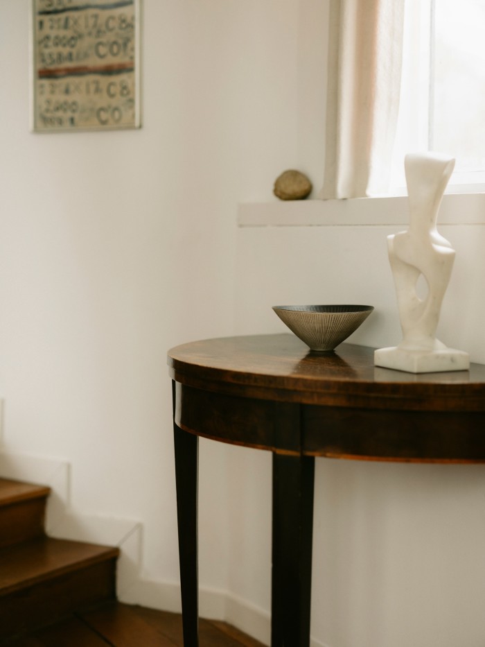 Bowl (brown and white inlaid lines), 1974, by Lucie Rie, and Spirality, 1970-75, by Kenji Umeda. On the wall is Letter and numbers, c1933, by Ben Nicholson