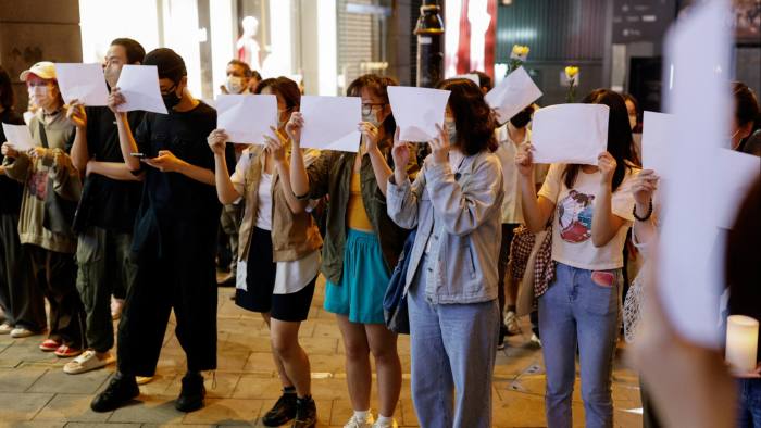 People hold sheets of paper in a protest in Hong Kong
