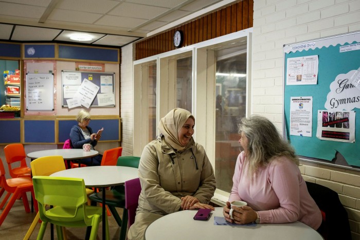 Picture of a Syrian woman and a volunteer English tutor. The language barrier can leave new arrivals feeling isolated.  While the UK does offer funding for providers of classes in English as a second language, this has been cut severely