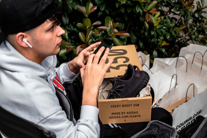 A man holding a box of Yeezy shoes