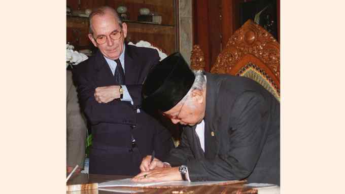 Indonesian President Suharto signing a new letter of agreement before International Monetary Fund (IMF) Director-General Michel Camdessus