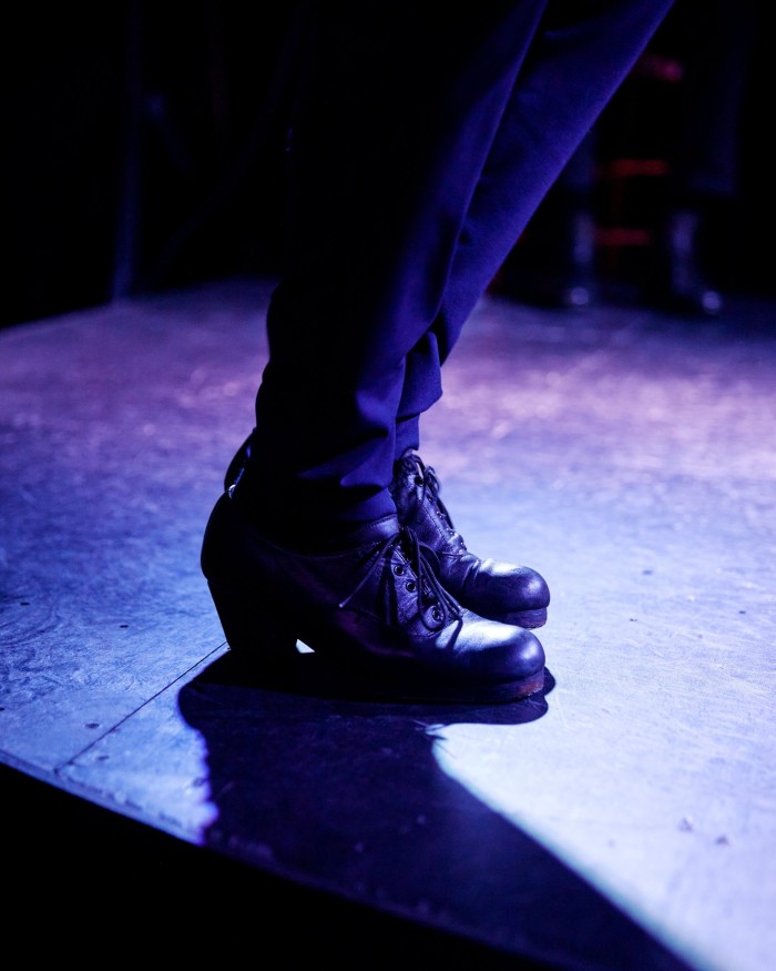 A pair of feet in heeled shoes on a stage