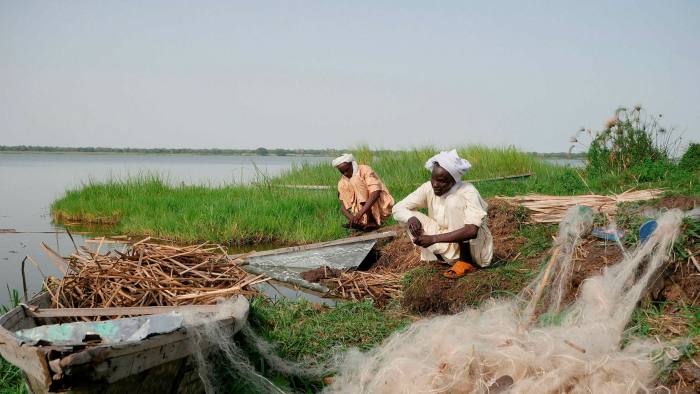 Chadian fishermen mend their nets on Midikouta Island on Lake Chad