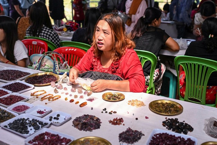 This photo taken on May 17, 2019 shows a seller trading rubies and other gemstones at the gems market in Mogok town, north of Mandalay